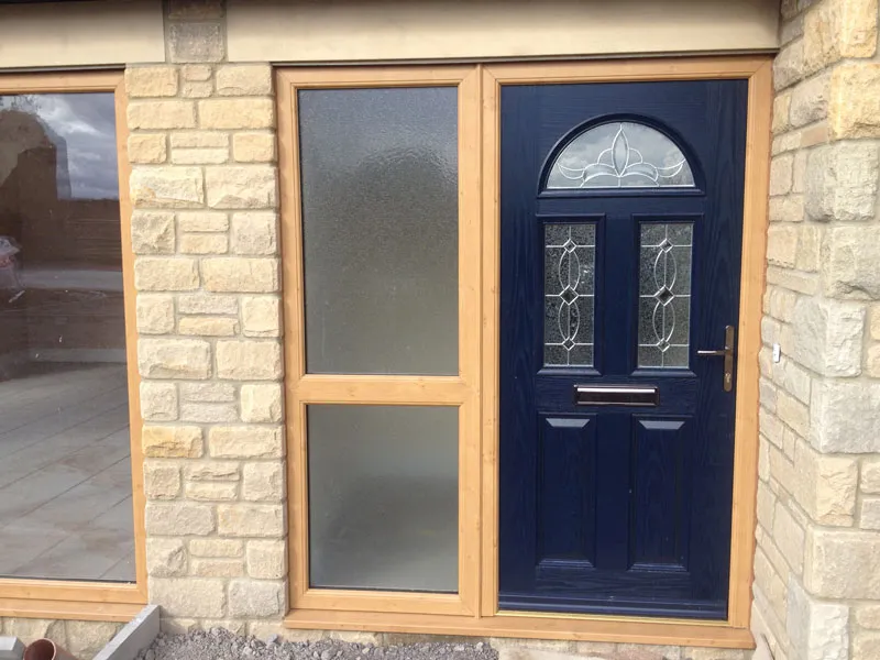 Navy composite front door with an oak woodgrain frame and obscure glass side panel