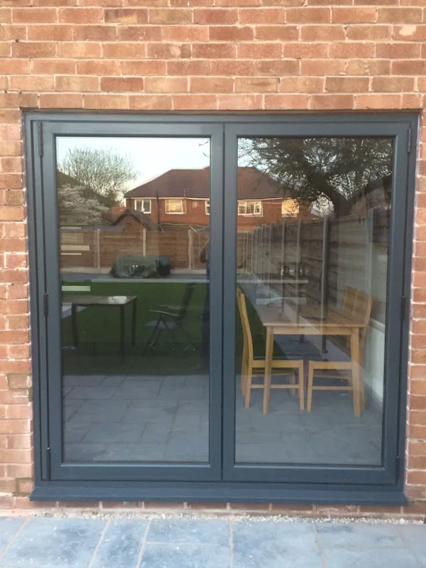 Anthracite grey French doors in a brick wall