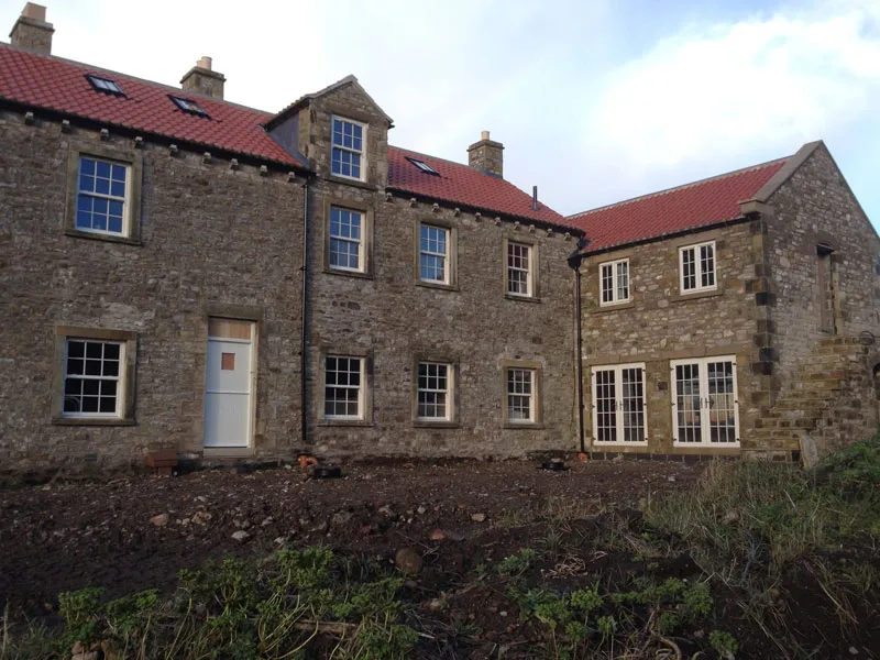 Stone farmhouses with new white windows and doors
