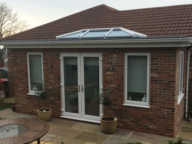 Brick extension with a roof lantern and white French doors