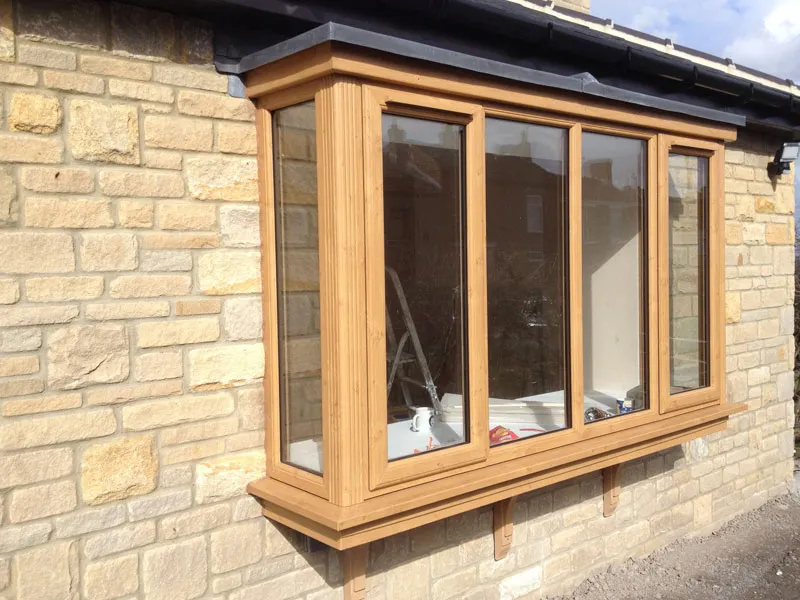 Oak woodgrain box bay window on a stone wall